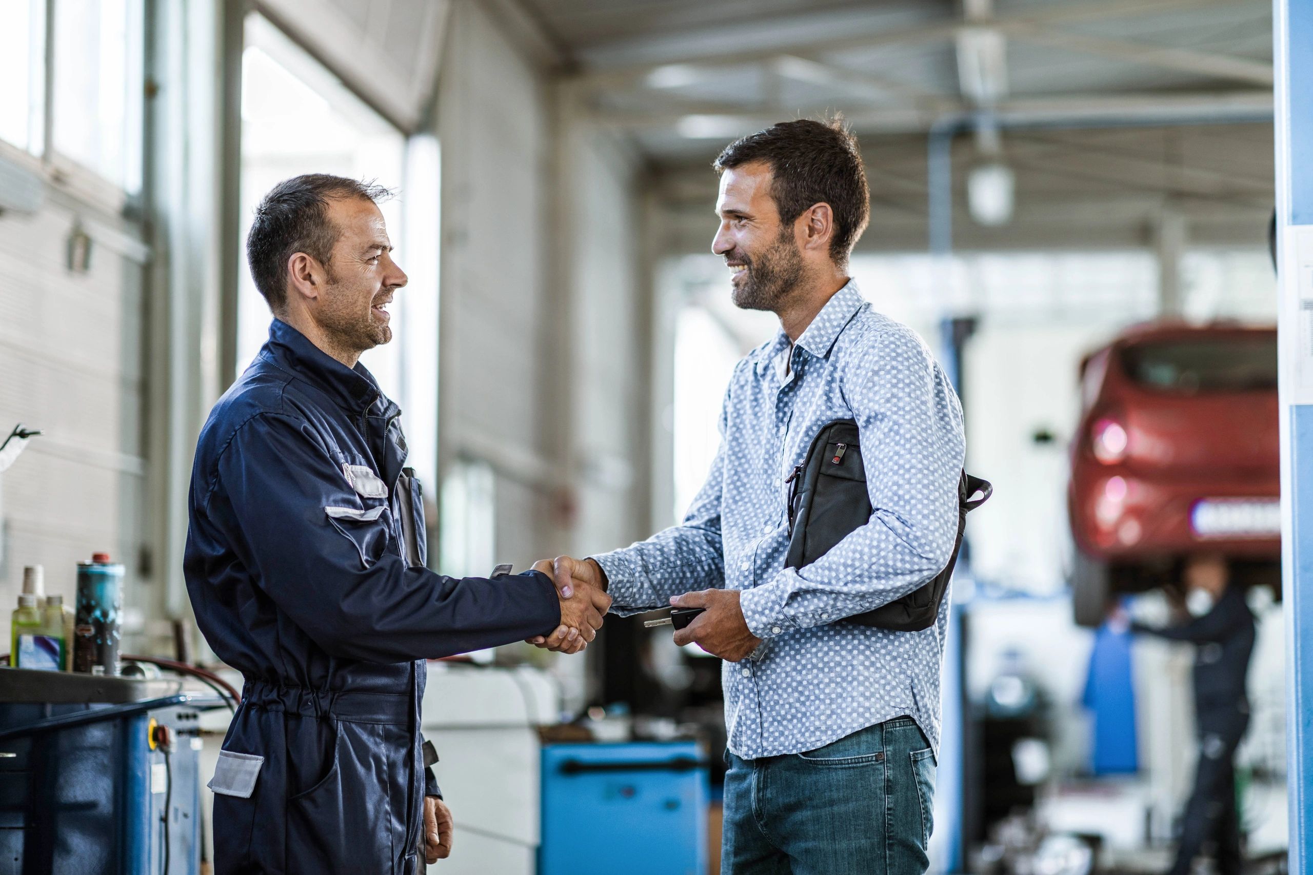 Customer and technician shaking hands after a vehicle service.