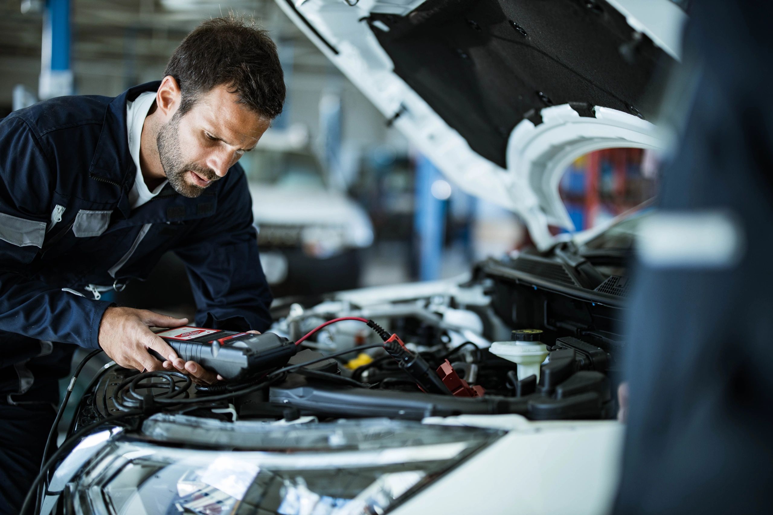Technician using a diagnostic tool during an EV battery health check.